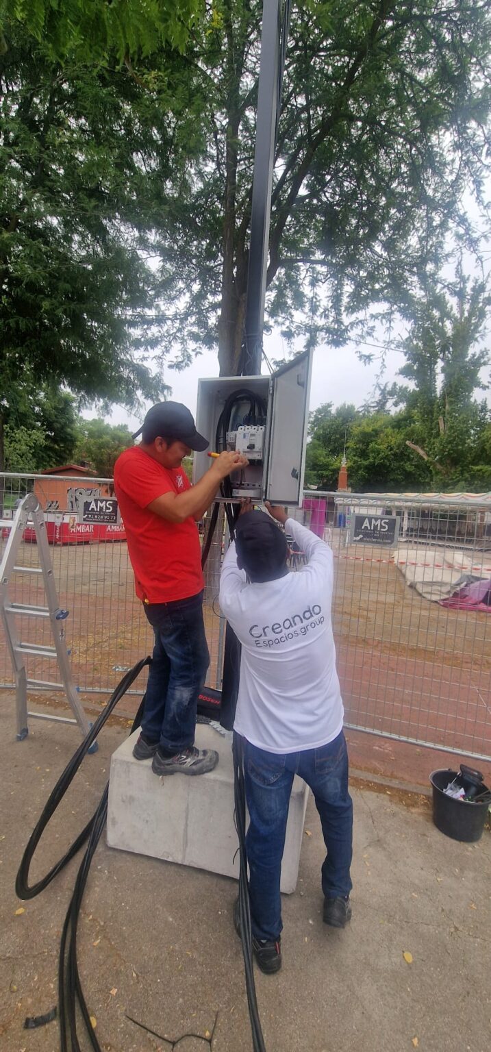 Electricista de guardia supervisando la conexión de varias casetas de feria.